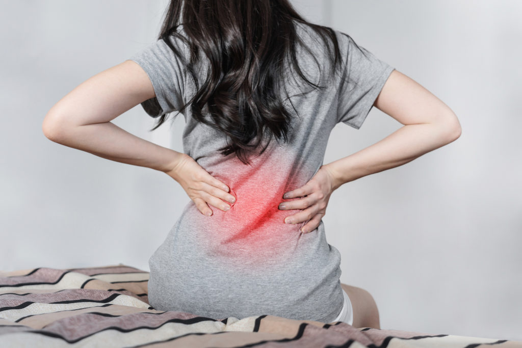 woman holding her lower back due to pain