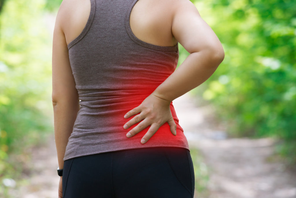 woman hiking suddenly feel pain in her back due to sciatica