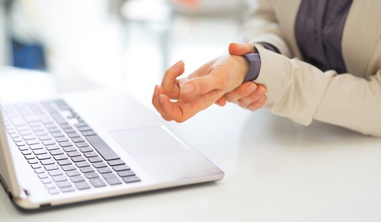 closeup on business woman with wrist pain